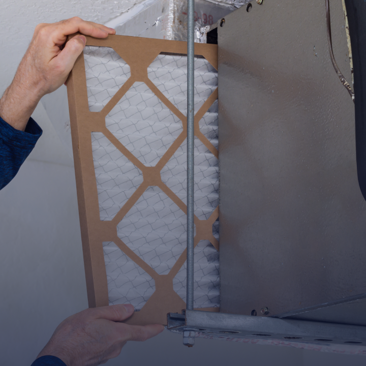 A person replace a furnace filter