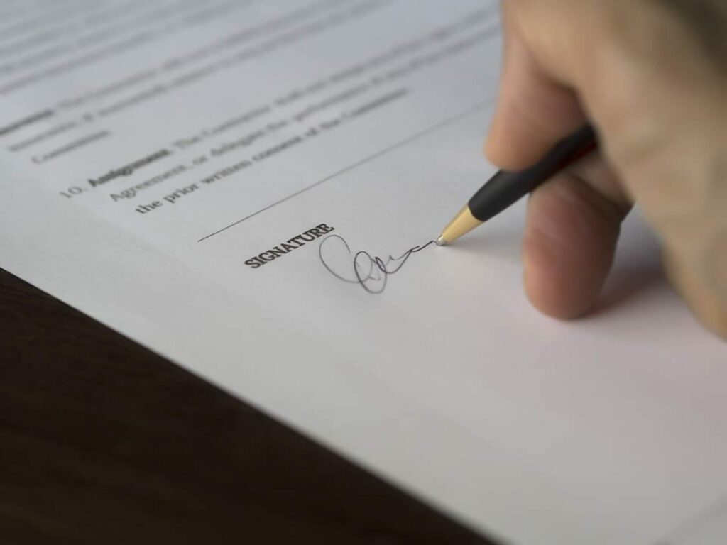 Close up shot of hand signing a document