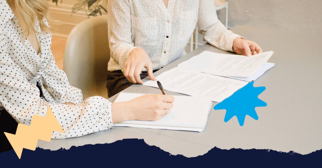 Close up shot of two women sorting through documents