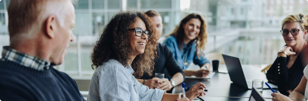 professionals working in office smiling at one another