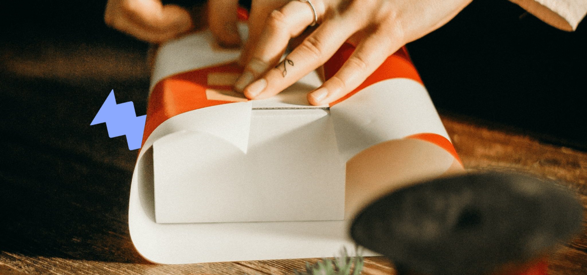 A person wrapping a gift with Christmas paper