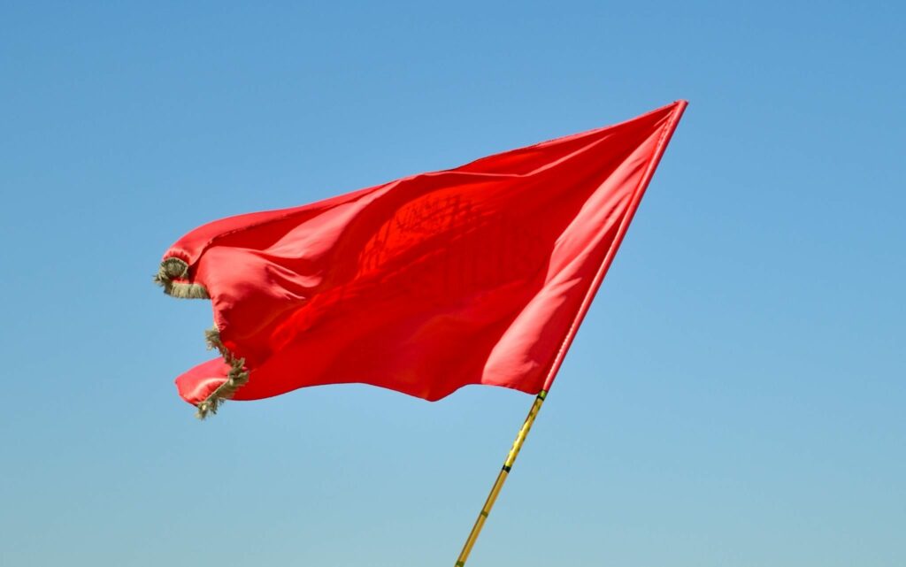 Red flag waving in the blue sky