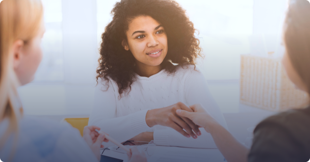 A person taking part in the rental application process and shaking hands with another person.