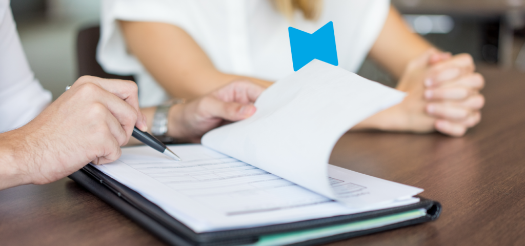 A close-up of someone pointing with a pen at a piece of paper during the tenant screening process.