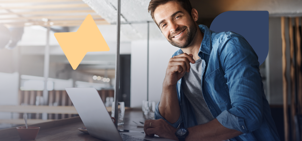 A person sitting in front of a laptop and smiling while reviewing a rent guarantee policy.