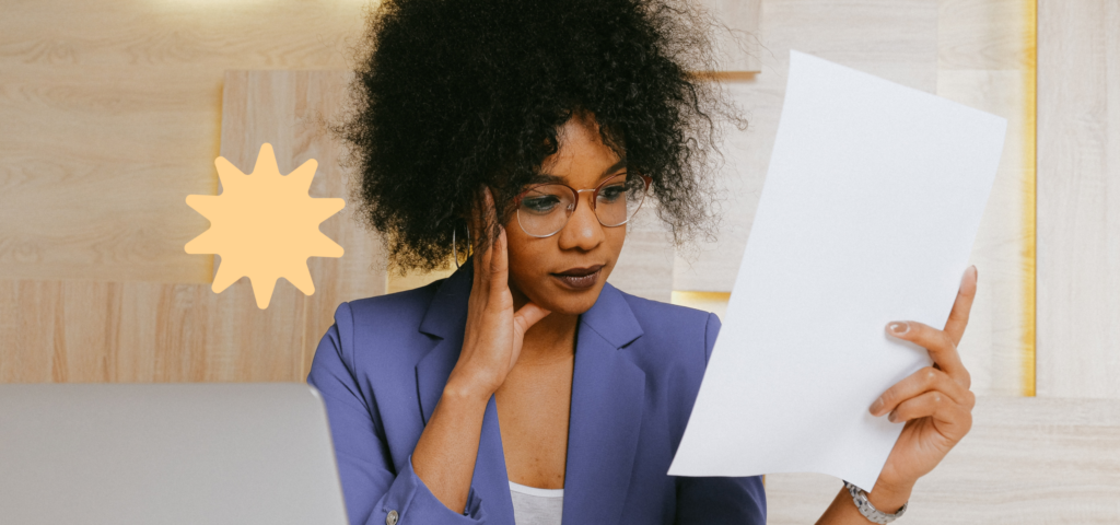 A person holding up a piece of paper and reviewing a renters insurance policy