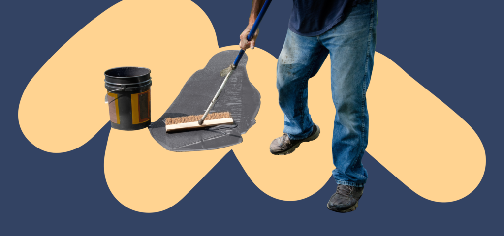 A person brushing concrete mix over a driveway