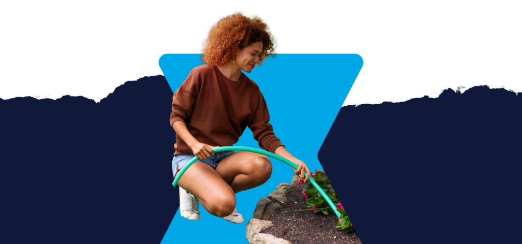 A person performing lawn maintenance by watering grass with a hose